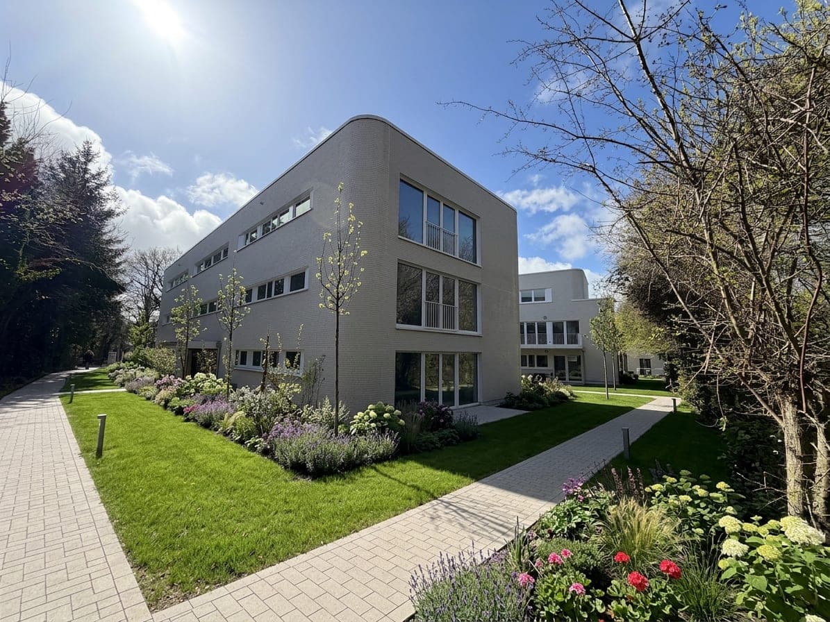 Sonnige Ostansicht mit heller Klinkerriemchen-Fassade, Staudenbeeten und Gartenweg